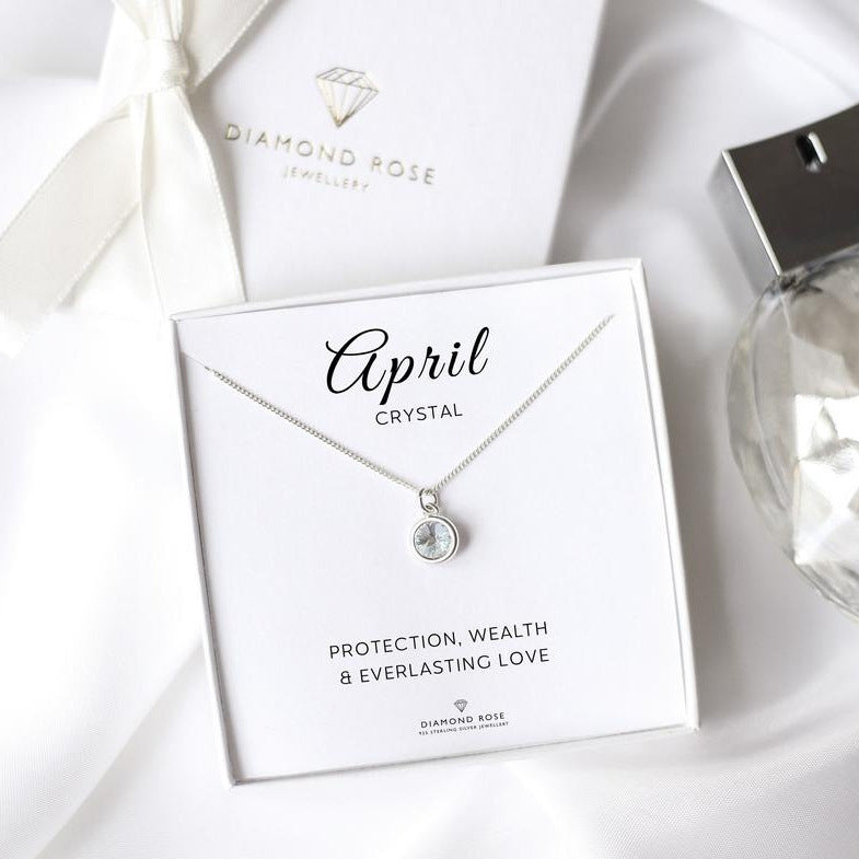 Diamond Rose jewelry box with a necklace featuring an emerald stone on a white background.