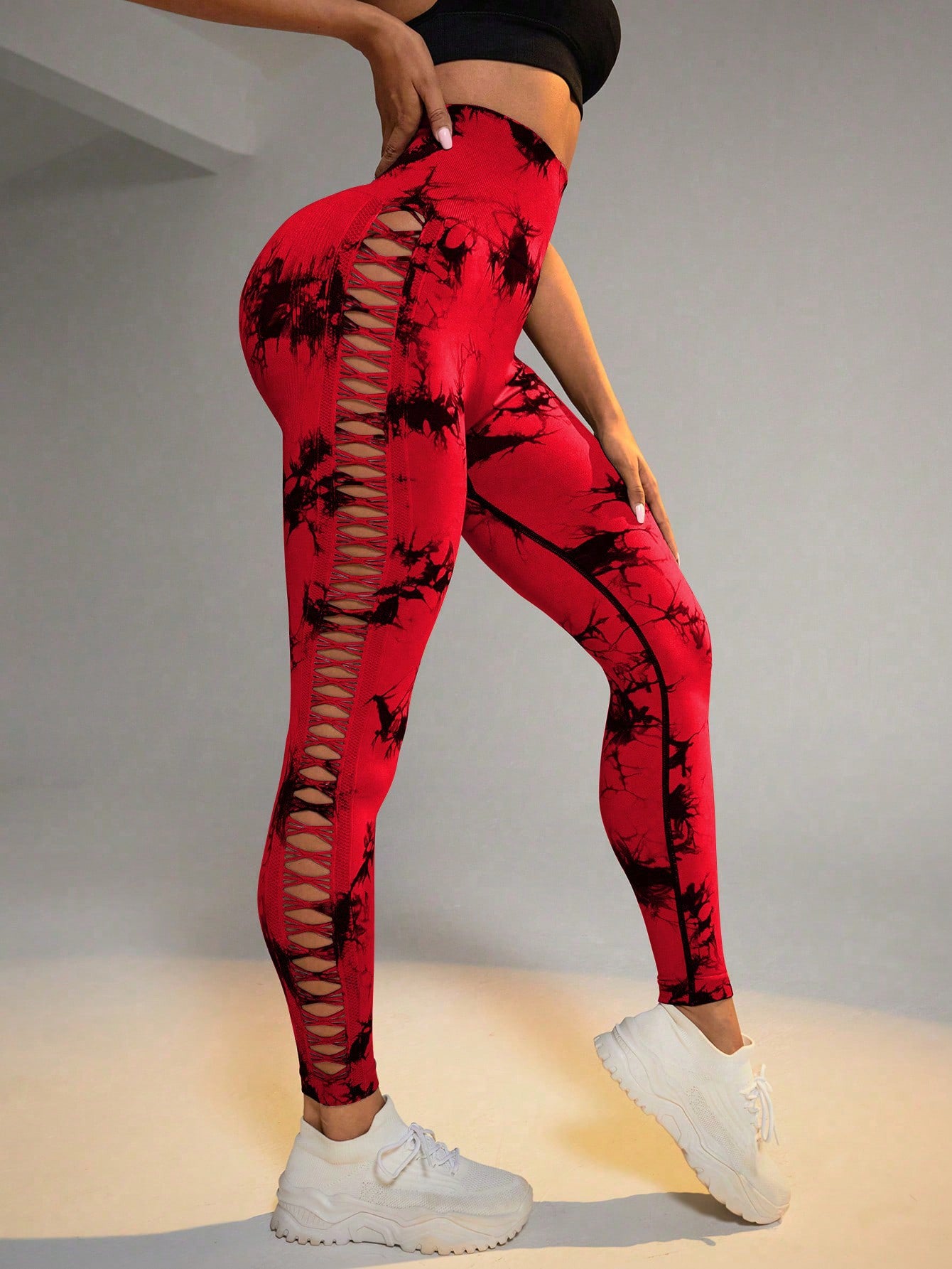 Red leggings with black patterns worn by a person on a neutral background