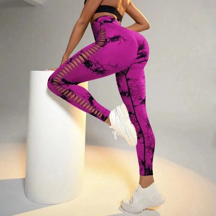 Person wearing purple leggings with black abstract design on a gray background