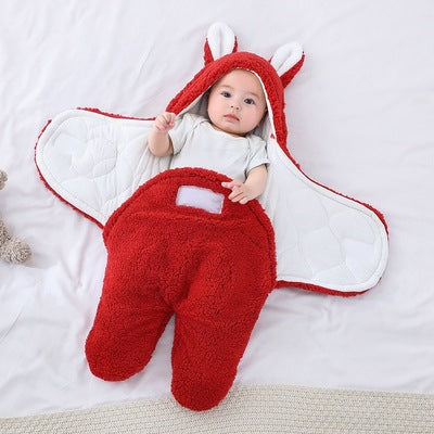 Baby in a red and white fox costume on a light gray background
