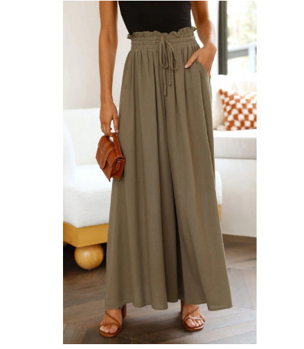 Person wearing olive green wide-leg pants with a blurred indoor background