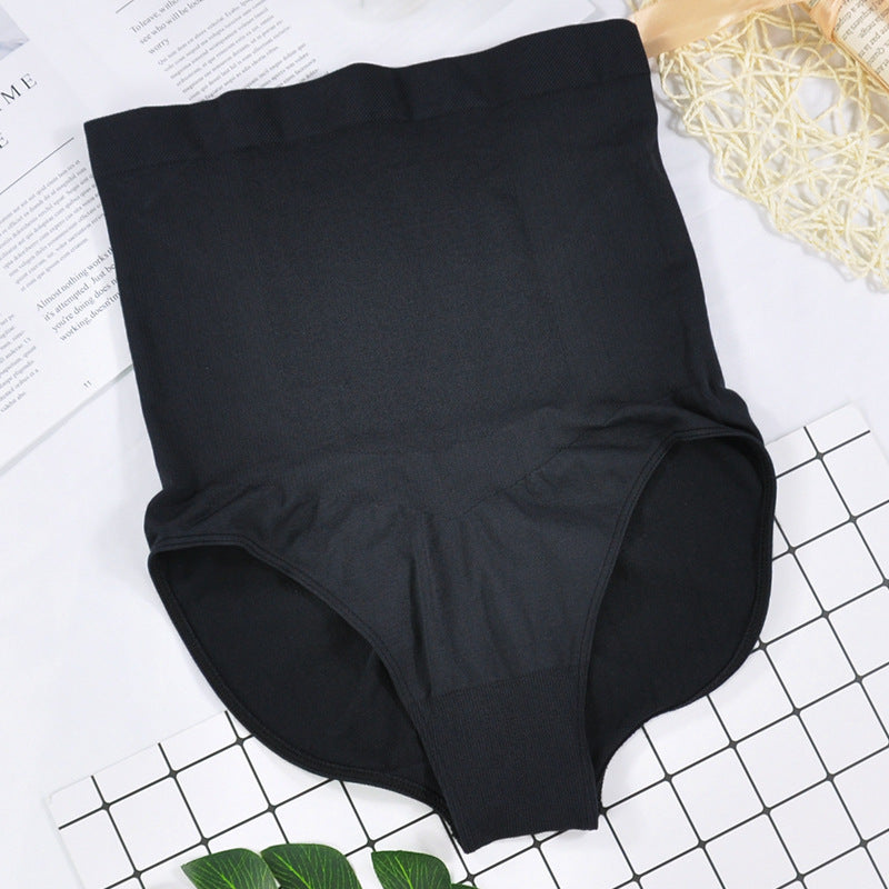 Black high-waisted underwear on a white surface with a grid pattern