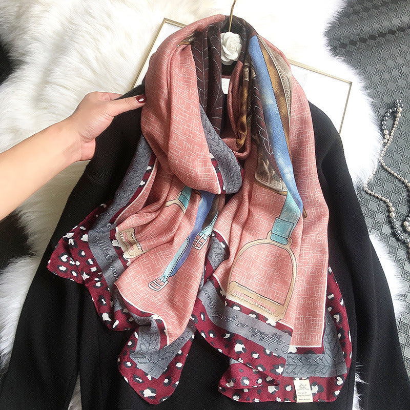 Colorful scarf with patterns draped over a person, against a textured white background.