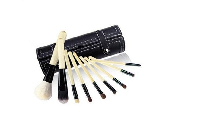 Set of makeup brushes with a black leather case on a white background