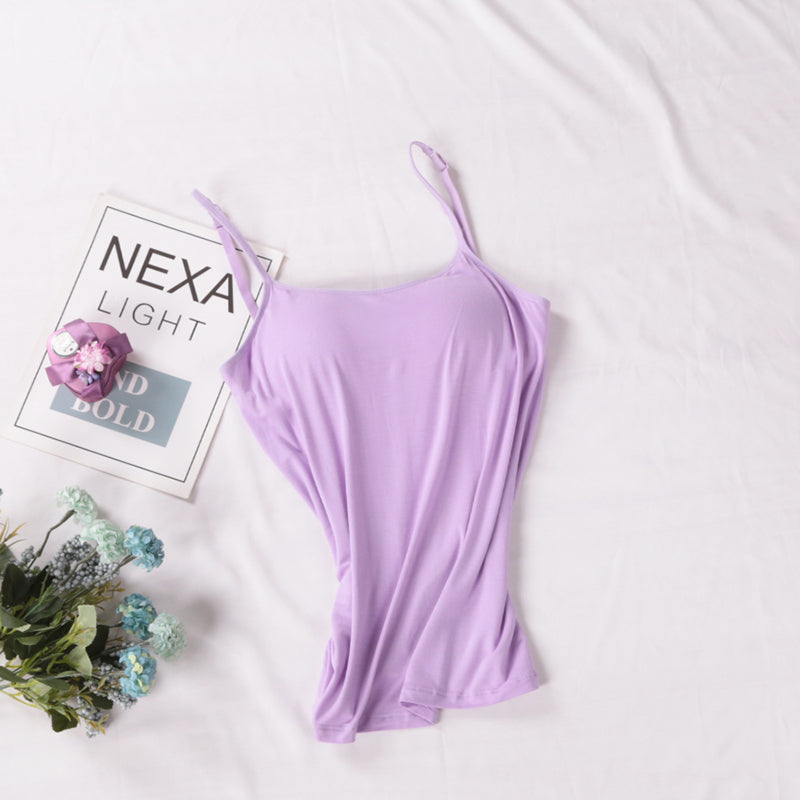 Purple strappy top on a light background with flowers and a magazine.