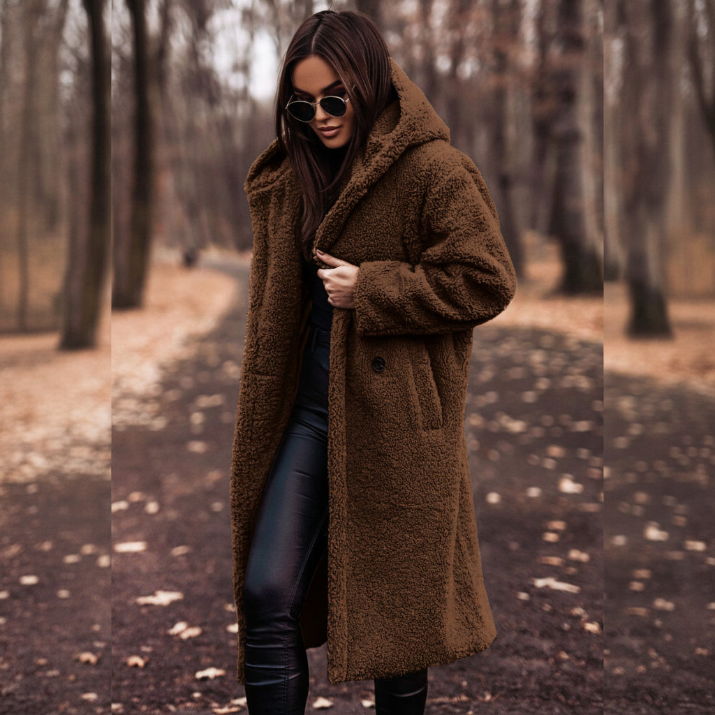 Woman wearing a brown coat in a forest setting