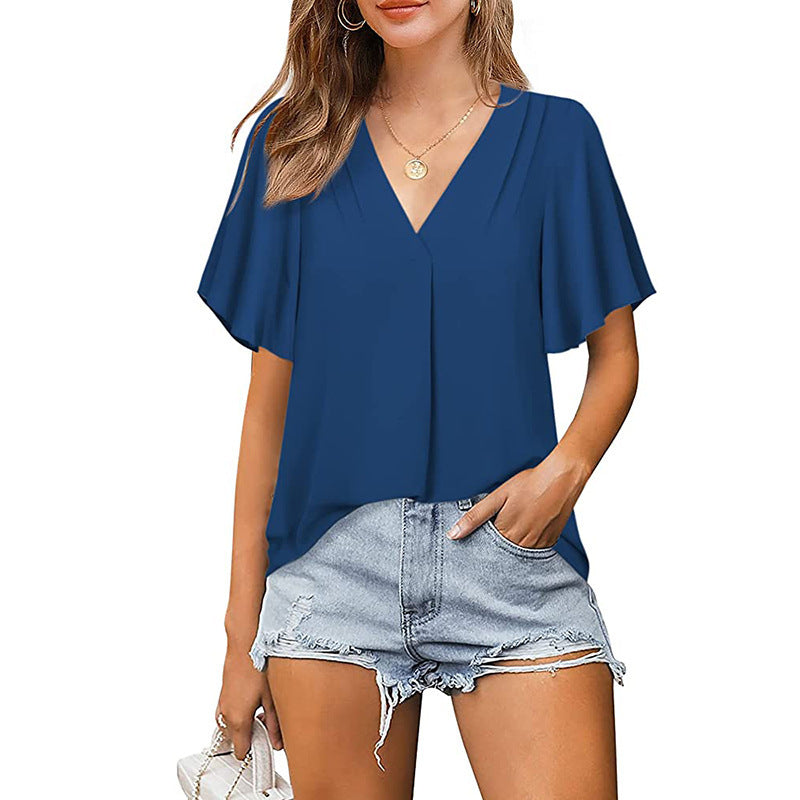 Woman wearing a blue top and denim shorts on a white background