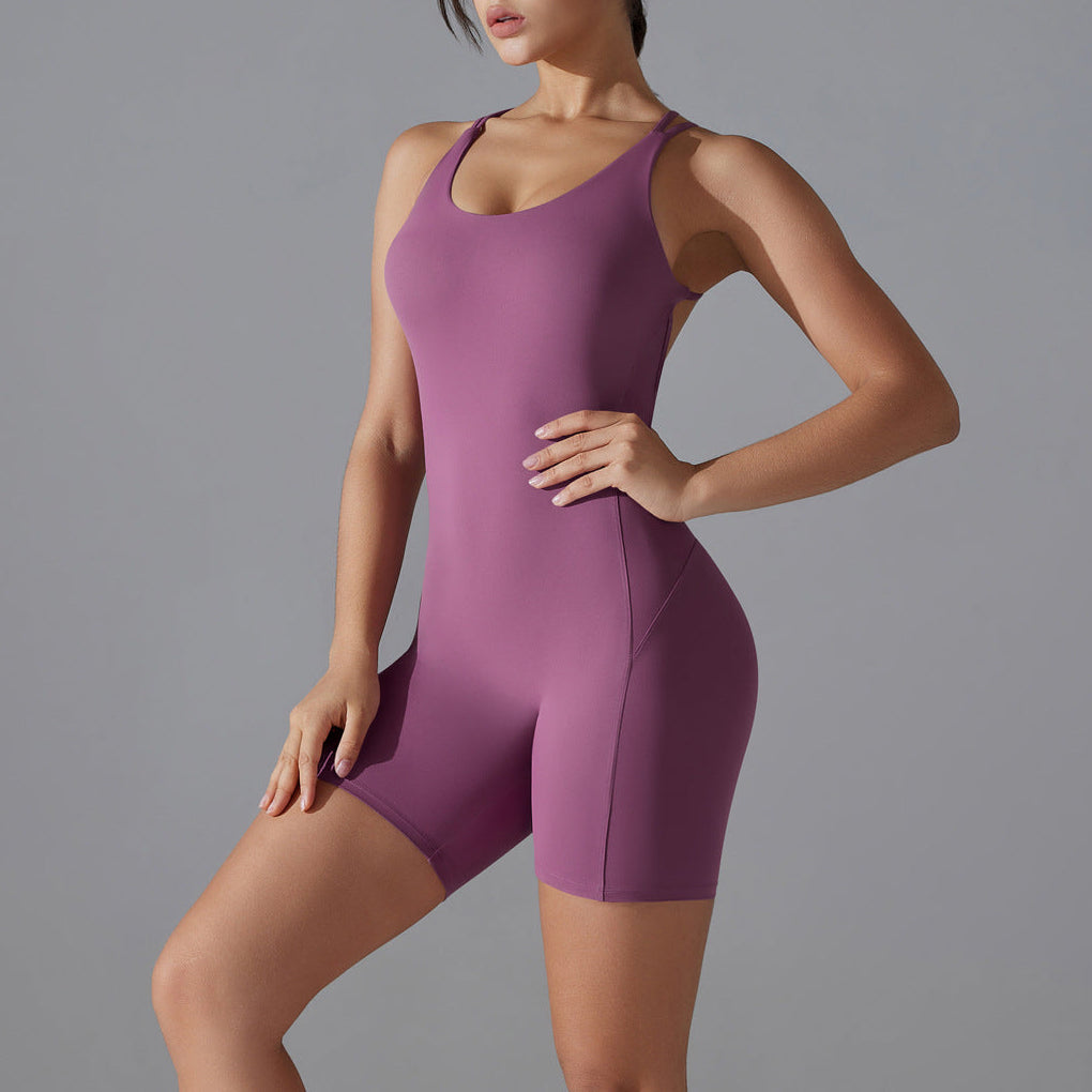 Woman wearing a purple bodysuit against a gray background