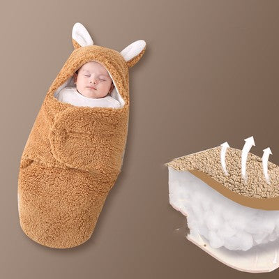 Baby wrapped in a brown animal-themed swaddle on a brown background