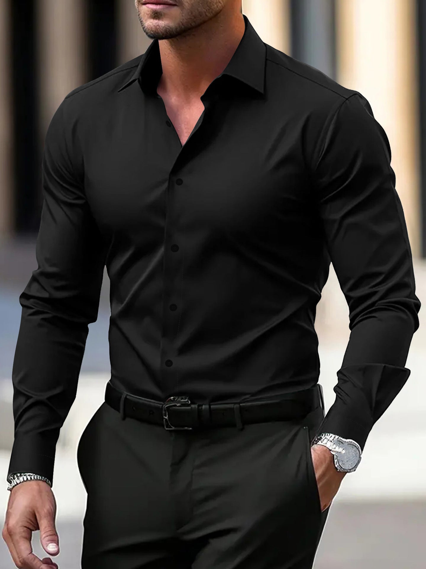 Man wearing a black dress shirt and pants with a blurred background