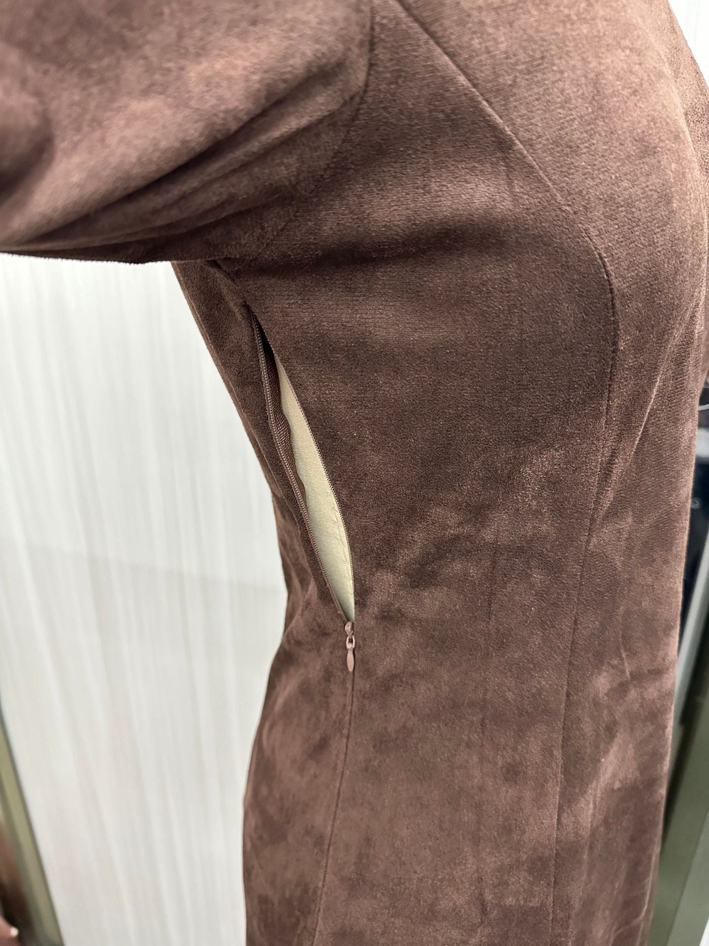 Brown suede jacket with a zipper on a white background