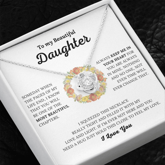Necklace with floral design and heartfelt message for a daughter on a white box.