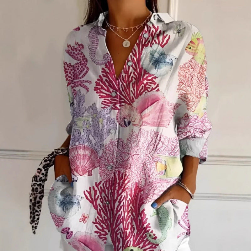 Person wearing a colorful coral patterned dress with a plain background