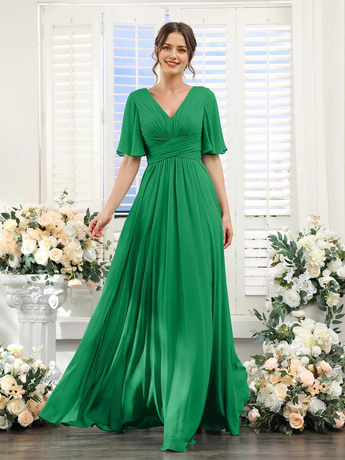 Woman wearing a green dress standing in front of floral decorations