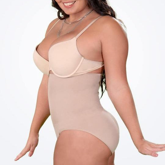 Woman wearing a beige bodysuit against a white background