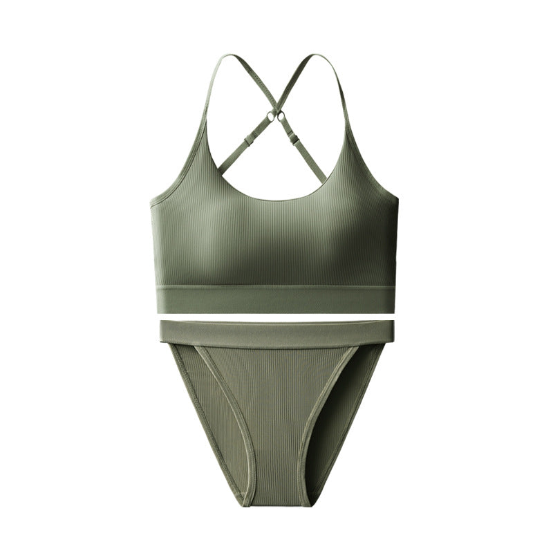 An olive green two-piece swimsuit featuring a ribbed sports bra top with crisscross straps and matching high-waisted bikini bottoms, shown against a plain white background.