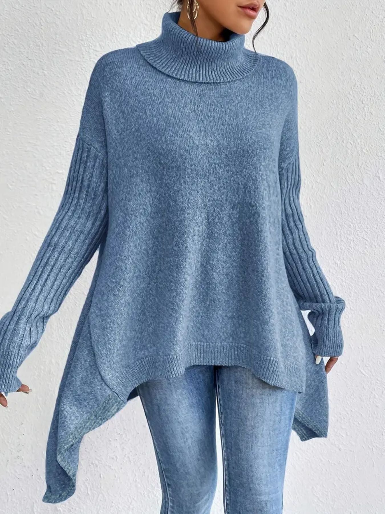 Person wearing a blue sweater and jeans against a white background