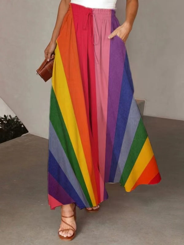 Person wearing a colorful rainbow skirt with a neutral background