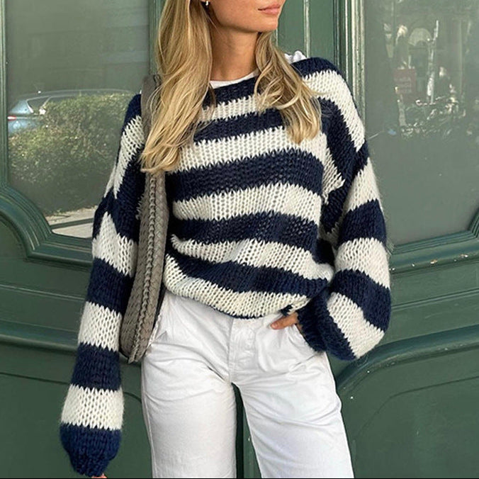 Woman wearing a navy and white striped sweater in front of a green door.