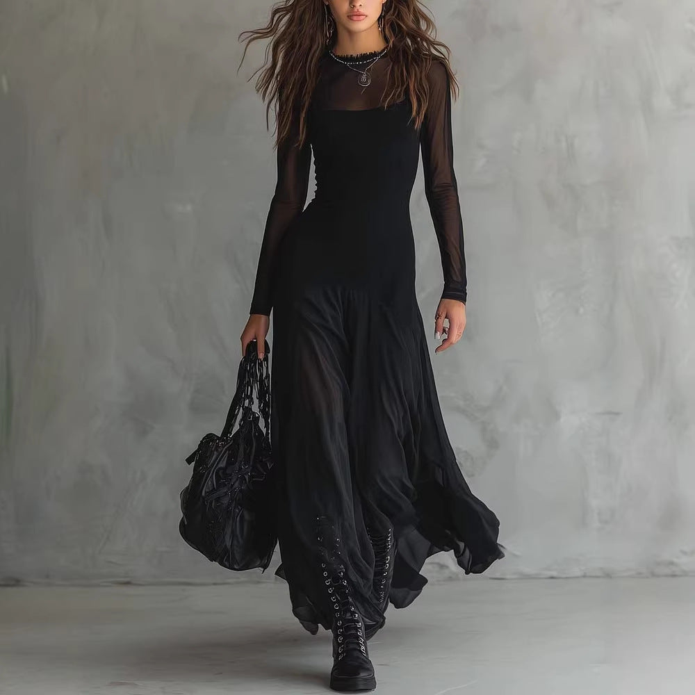 Woman wearing a black dress and holding a black bag against a gray background