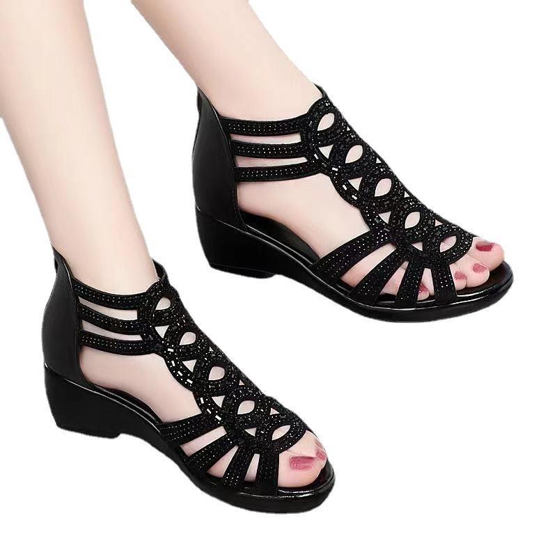 Black open-toe sandals with a wedge heel on a white background