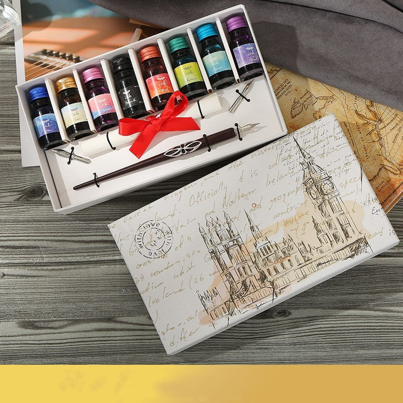 Ink set with bottles, a pen, and a decorative box on a wooden surface