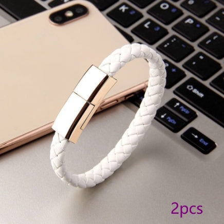 White braided bracelet with rose gold clasp on a laptop keyboard