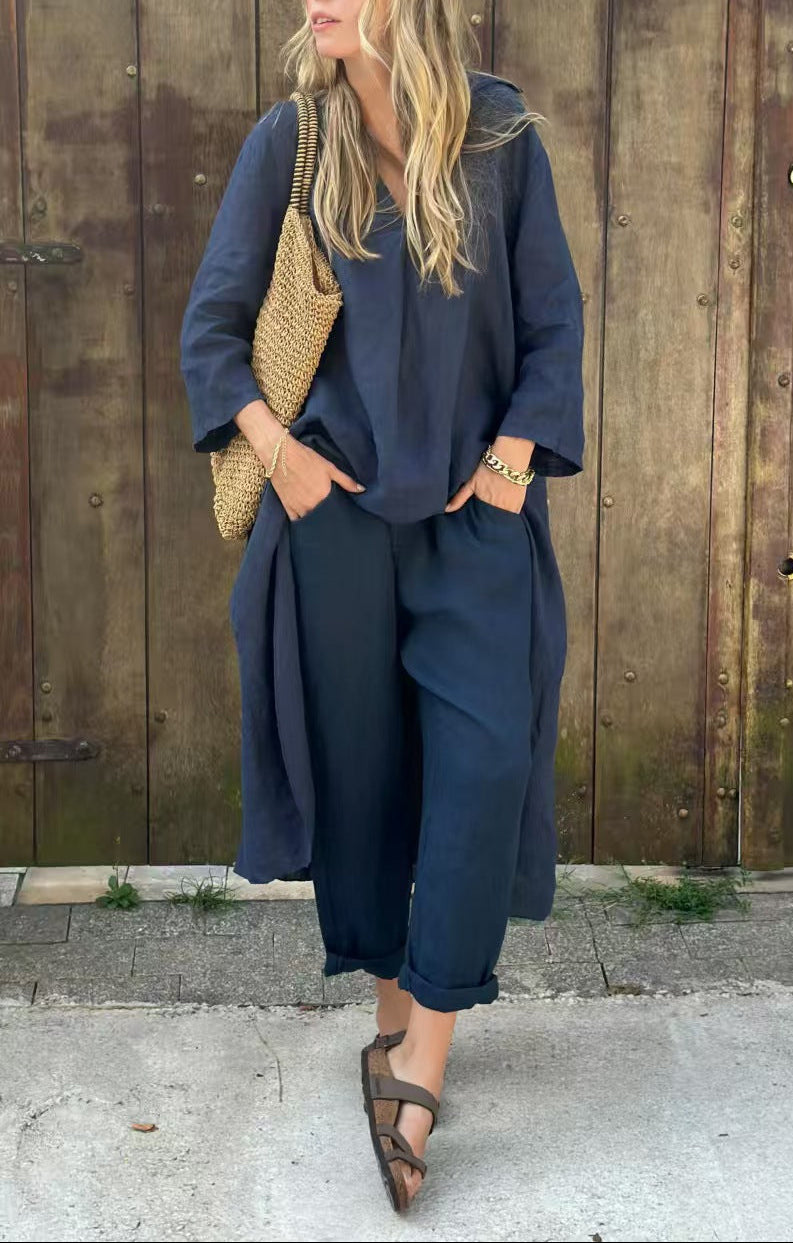 Woman in a navy outfit standing against a wooden wall.