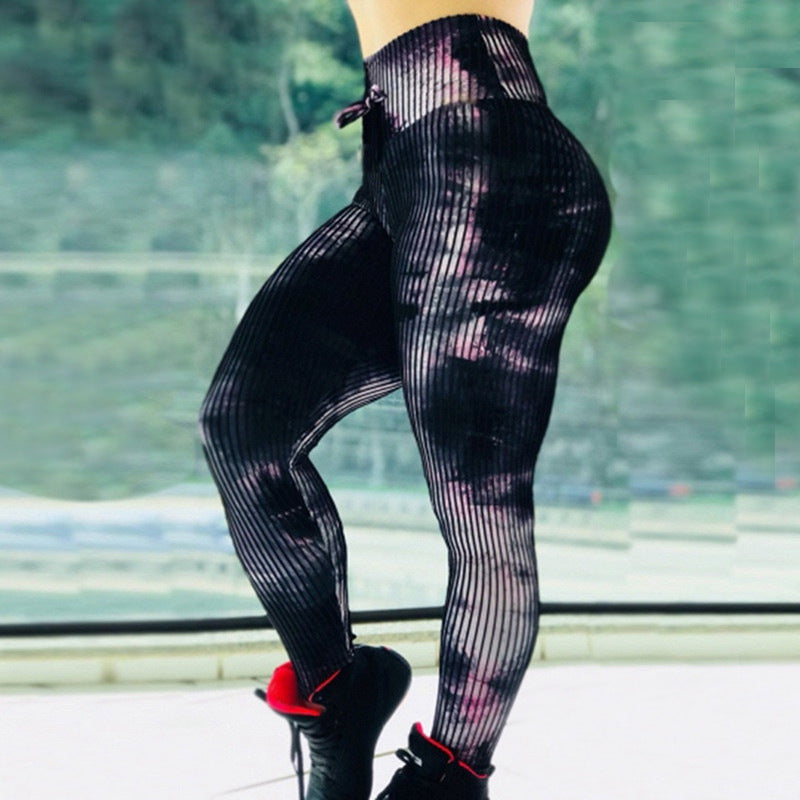 Black fishnet leggings worn by a person with a blurred green outdoor background
