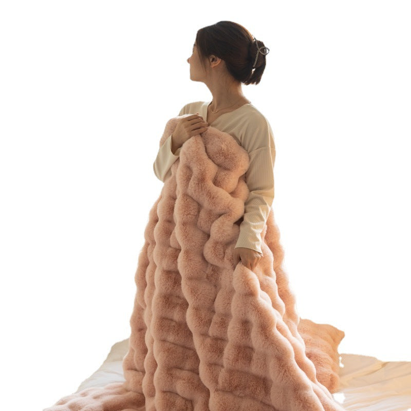 Person wrapped in a large pink blanket on a white background