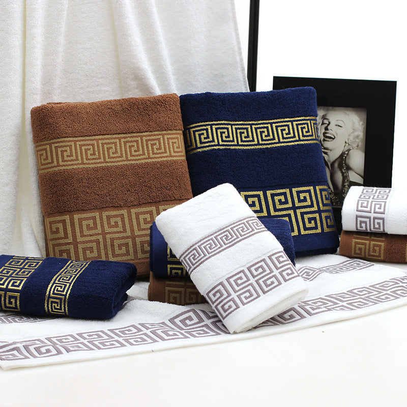 Set of patterned towels in brown, blue, and white on a white surface.