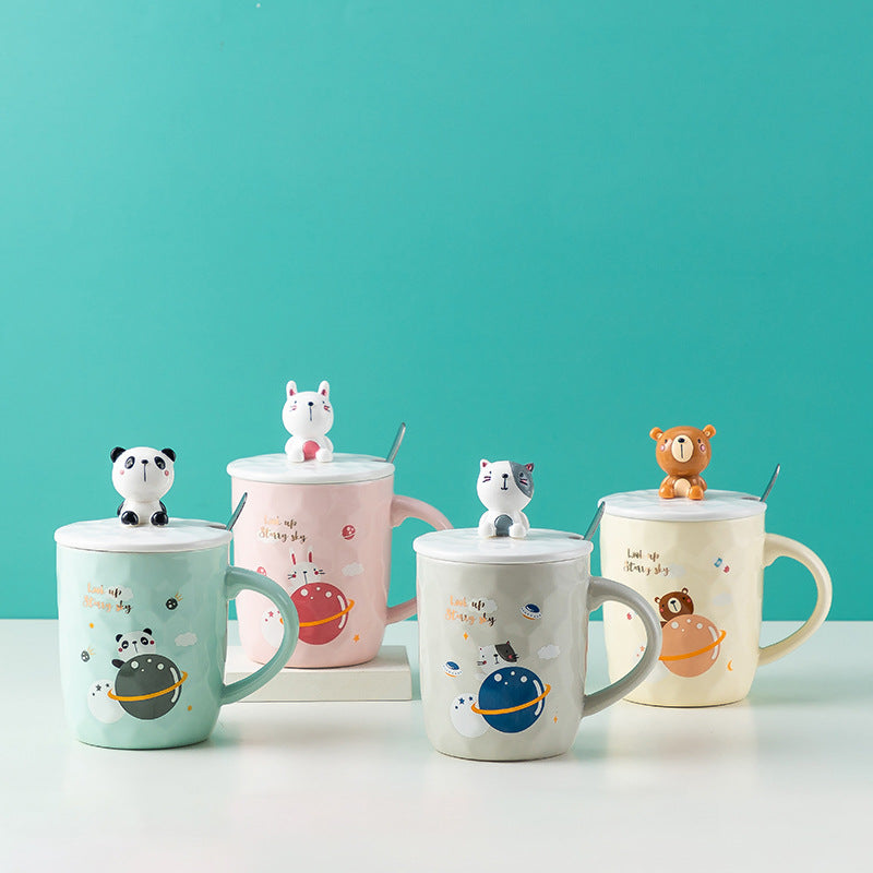 Set of four ceramic mugs with animal-shaped lids on a teal background