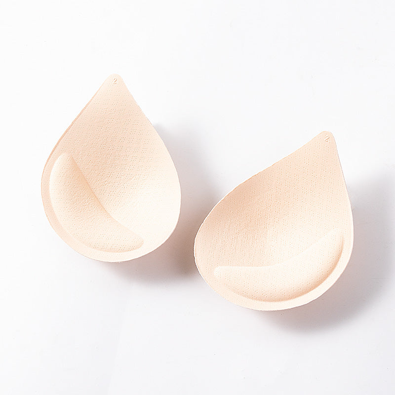Two beige teardrop-shaped silicone pads on a white background