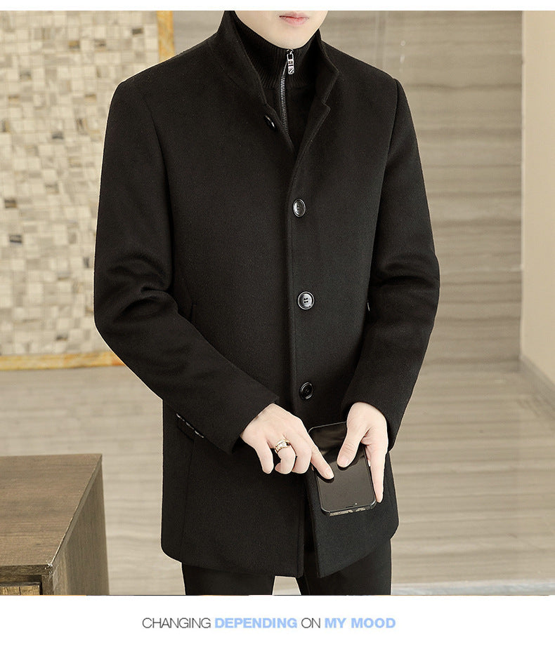 Person wearing a black coat holding a phone in an indoor setting