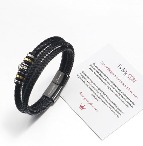 Black braided bracelet with metal accents on a white background