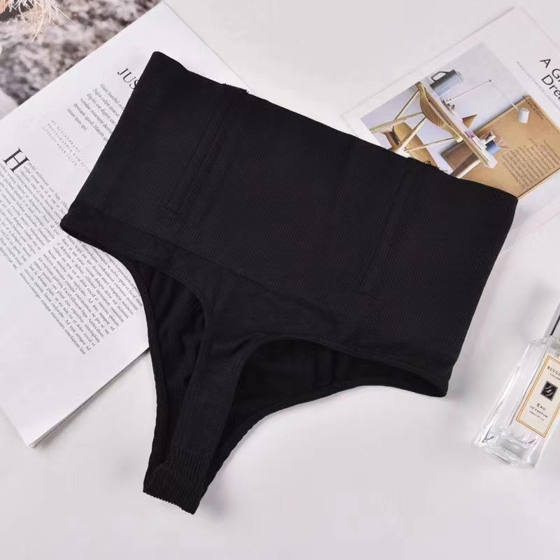 Black underwear on a white surface with a magazine in the background