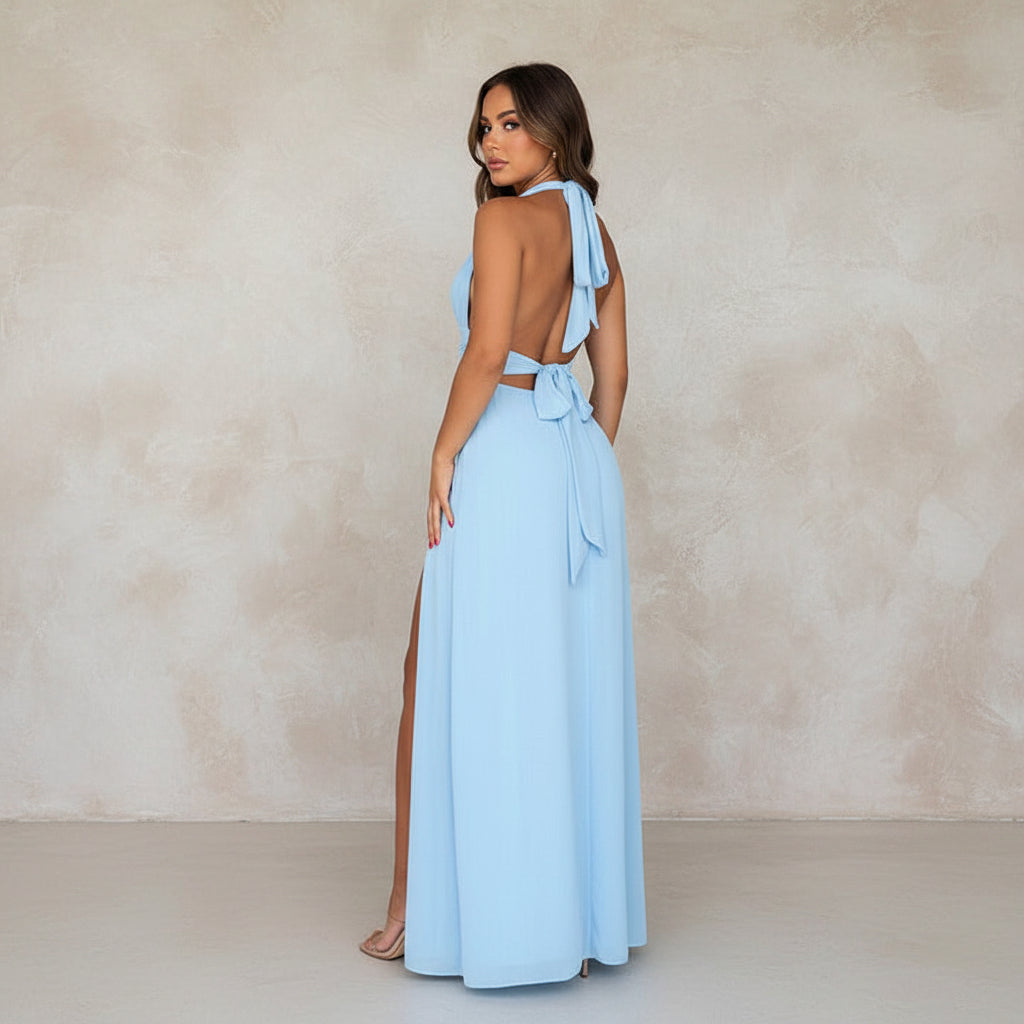 Woman in a light blue dress standing in a modern living room.