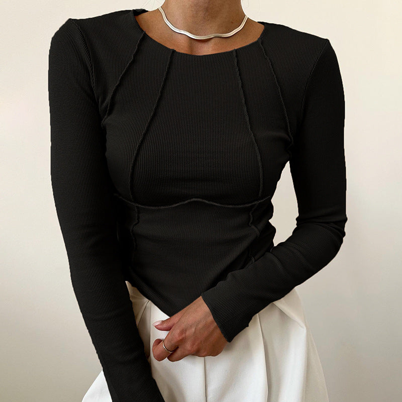 Person wearing a black long-sleeve top with a plain background