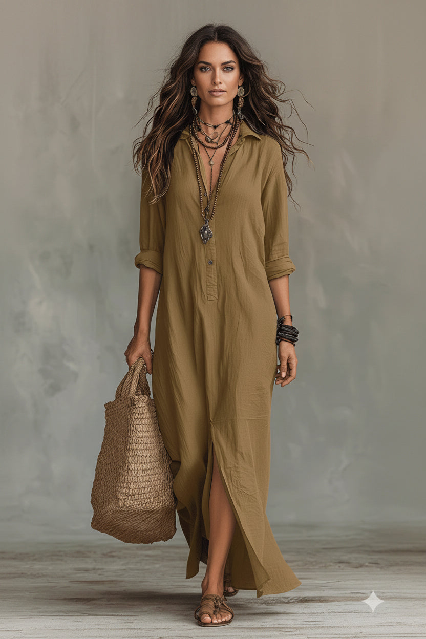 Woman wearing a long olive green dress holding a woven bag against a gray background