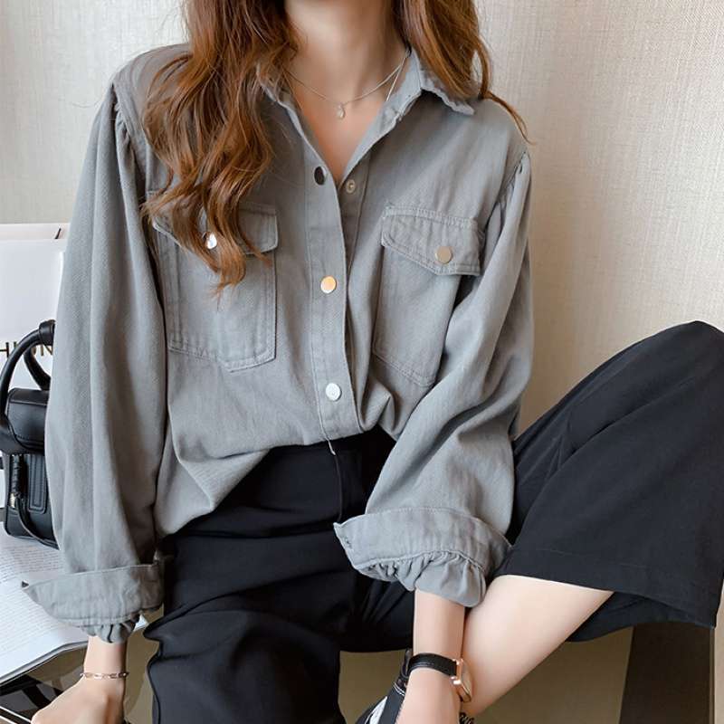 Person wearing a gray shirt and black pants sitting on a chair.