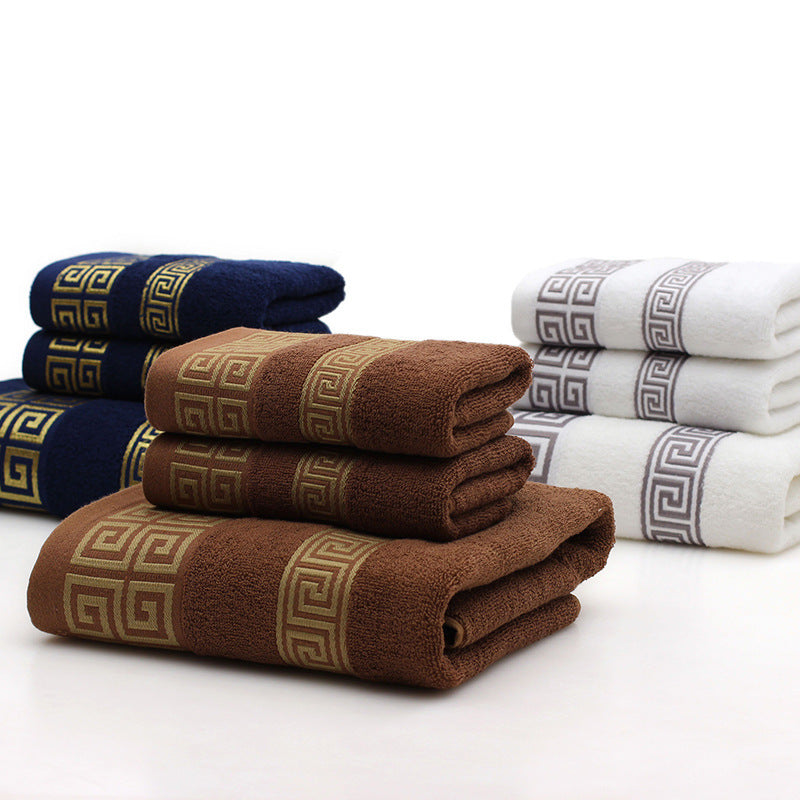 Stack of folded towels in brown, blue, and white with decorative patterns on a white background