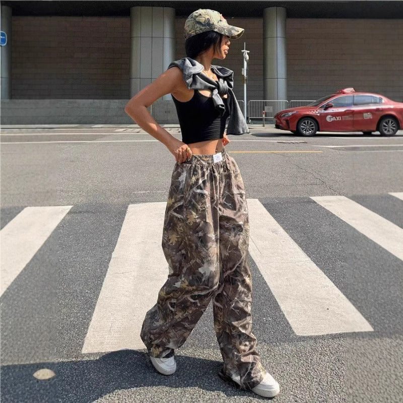 Person wearing camouflage pants and a cap on a city street