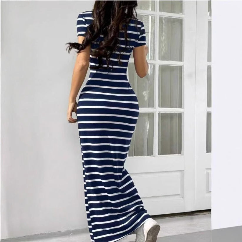 Woman wearing a blue and white striped dress in a room with a white door.