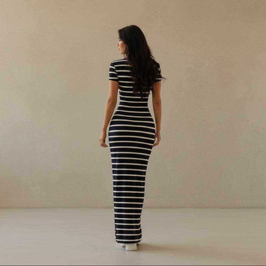 Woman wearing a blue and white striped dress in a room with a white door.