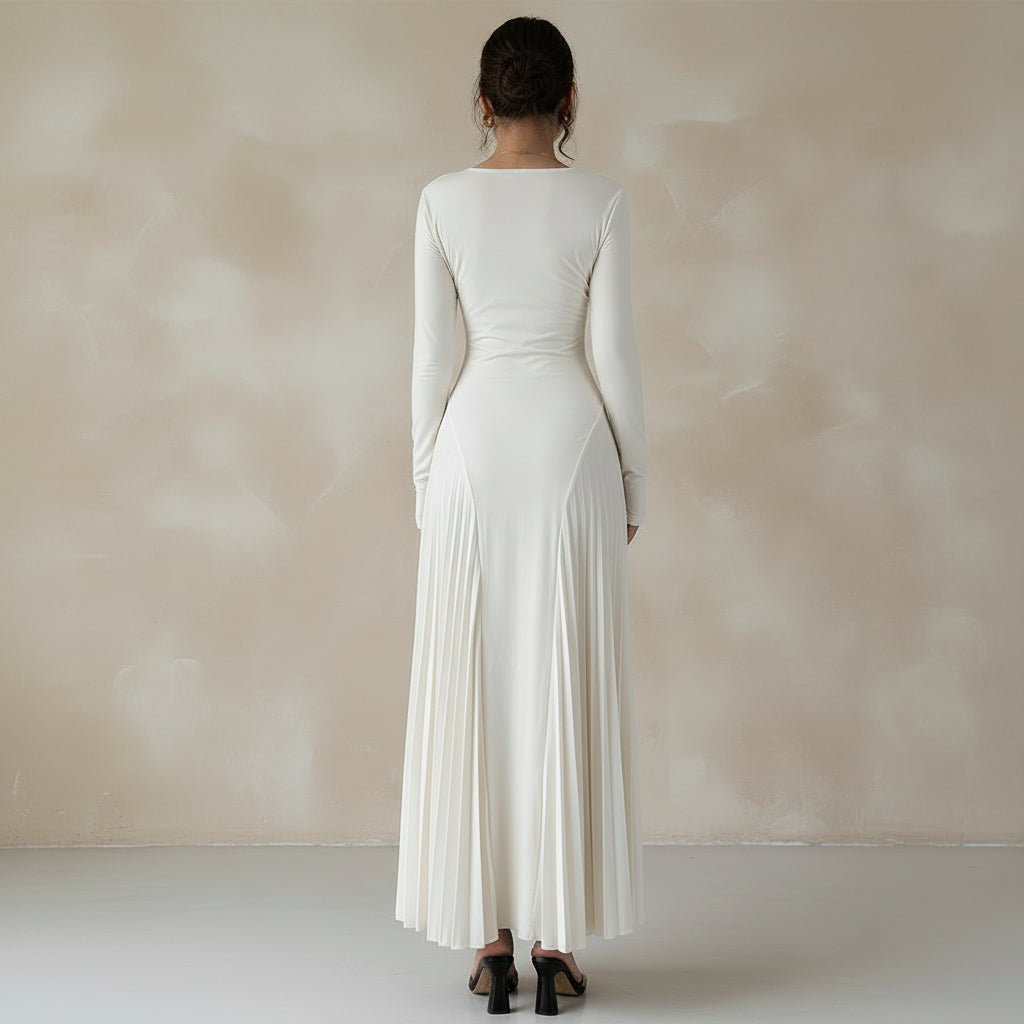 White pleated dress worn by a person against a plain background