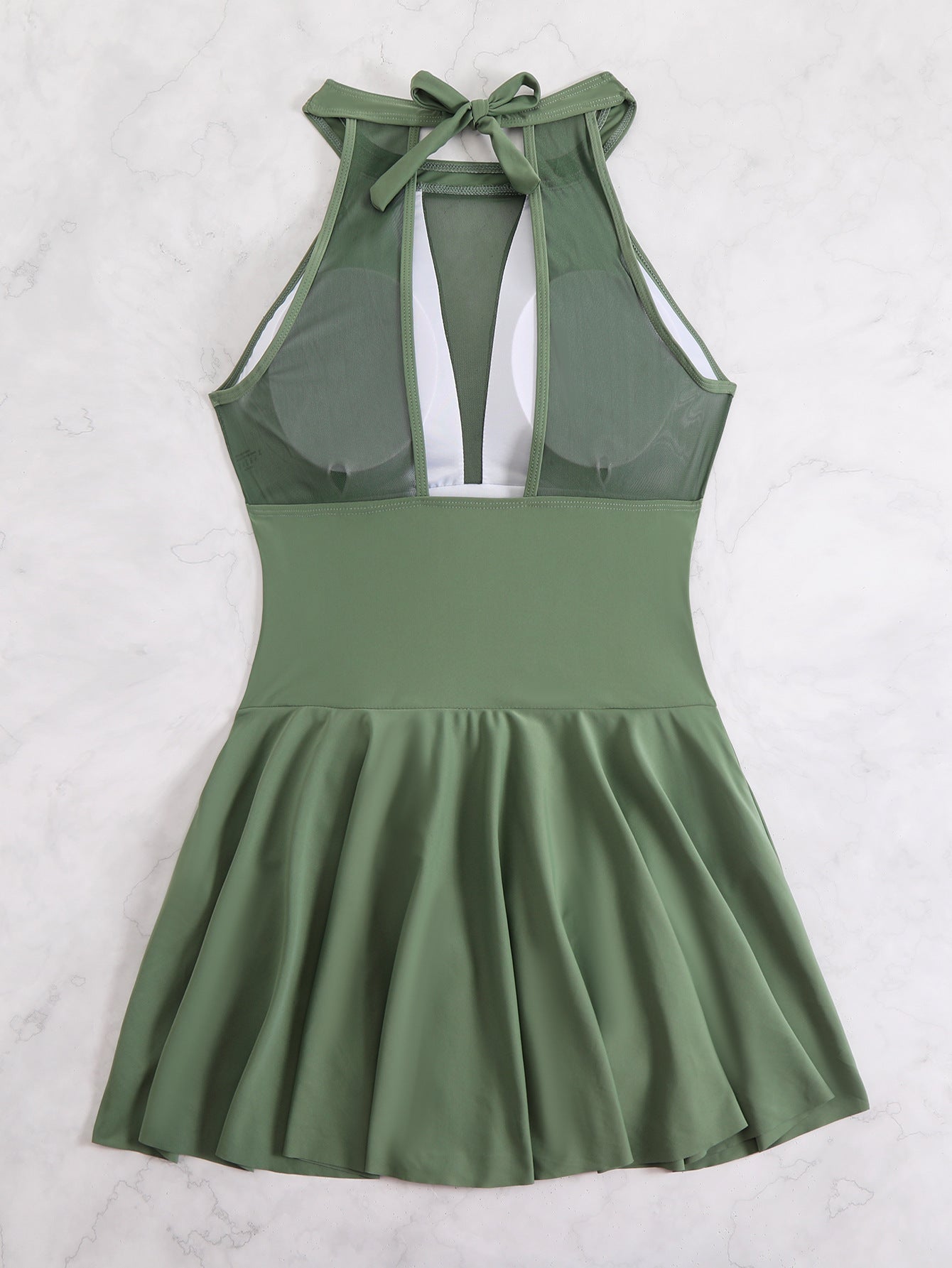 Green dress with a bow detail on a white background