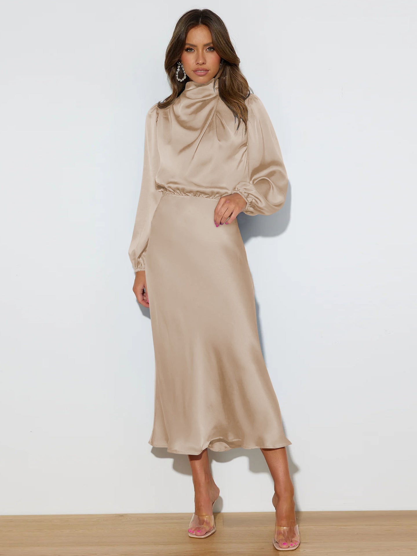 Woman wearing a beige dress with a plain white background