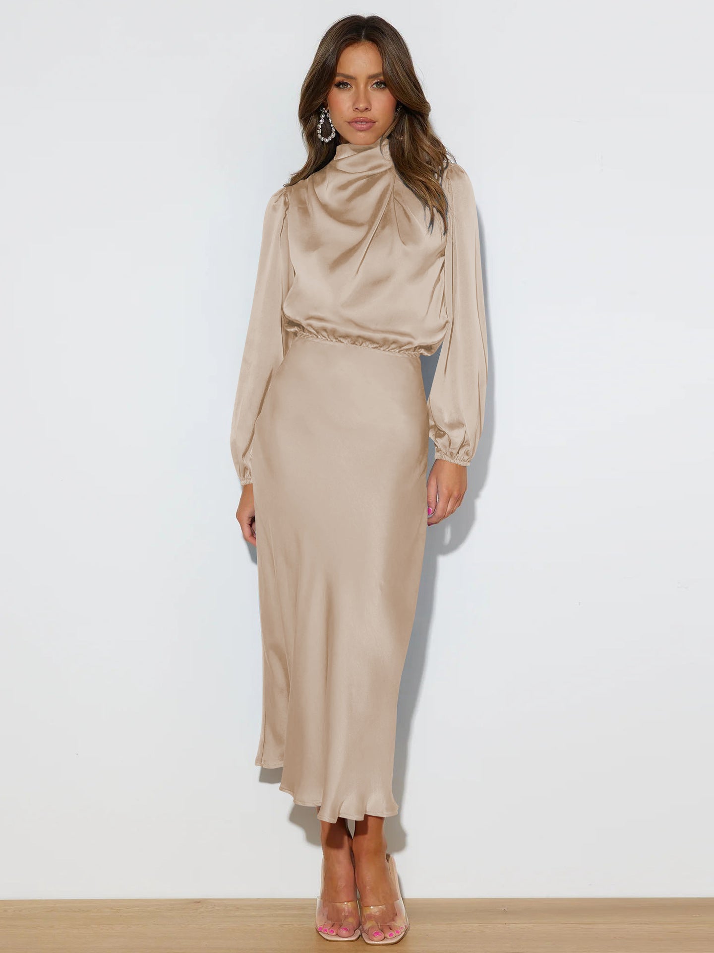 Woman wearing a beige long-sleeve top and skirt set on a white background