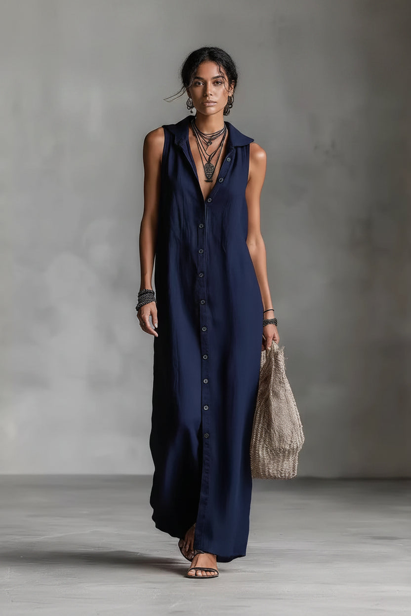 Woman wearing a long navy dress against a gray background