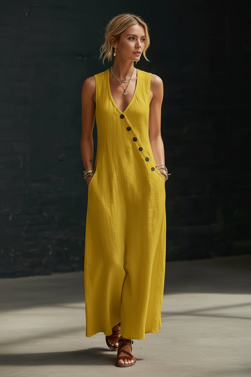 Woman wearing a yellow sleeveless dress with buttons against a dark background
